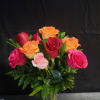A compact cluster of roses in vivid pink, deep red, orange and