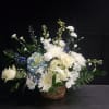 A serene mix of white roses and pale blue hydrangeas creates a