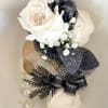 White roses adorned with baby's breath and black lace ribbon