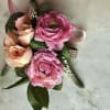 Complementing the ranunculus are light pink spray roses, eucalyptus and green leaves