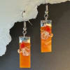 Glossy rectangular orange pendants catch the light in these handmade dangle earrings
