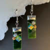 Deep, jewel-toned green glass catches the light in these artisan dangle earrings