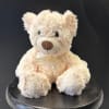 A cuddly cream plush teddy bear creates an irresistible gift for Mother's