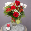 Red roses with white daisies, alstroemeria and carnations in a vase, accented