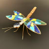 A jewel-toned mosaic dragonfly adds a splash of playful artistry to any