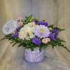 A graceful gathering of lavender and white blooms in a lavender vase