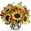 Bouquet of yellow sunflowers and orange roses in a clear glass vase