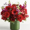 Red roses and mixed flowers in a green vase