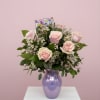 Celebrate Mom with this elegant arrangement featuring soft blush roses, white wax