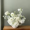 A lush garden of crisp white blooms, thoughtfully arranged with hydrangea, roses