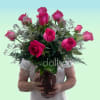Vivid hot pink roses cluster into a compact, hand-tied bouquet that reads
