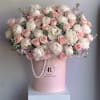 Large arrangement of white peonies and pink roses in a pink hatbox with pearl garlands.