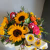 Bright golden sunflowers take center stage in this cheerful flower arrangement for