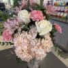 Soft pink roses and blushing hydrangeas mingle with pink carnations and delicate