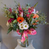 Bright gerbera daisies and soft pink roses create an immediate pop of