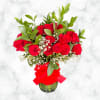 Red roses in a glass vase with baby's breath and a red ribbon