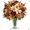 Bouquet of orange lilies and red roses in a clear glass vase
