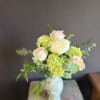A soft, romantic mix of pale peach roses and lush green hydrangeas