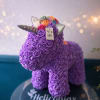 A cheerful unicorn-shaped floral figure covered in tightly packed purple silk roses-perfect