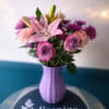 Pale pink lilies rise above a cloud of pink and lavender roses