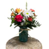 Mixed bouquet of daisies, carnations, and lilies in a blue glass vase