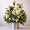 A single poised white lily crowns this Floral Christmas Tree arrangement, creating