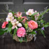 Pink and white flowers arranged in a woven basket