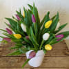 Bouquet of multicolored tulips in a white pot
