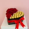 Heart-shaped box with red roses and gold-wrapped chocolates tied with a red ribbon
