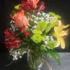 Coral and deep red roses mingle with sunny yellow lilies and lively