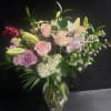 Soft pale pink roses mingle with fragrant white lilies in this romantic