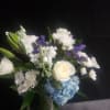 A serene bouquet centered on a large blue hydrangea gives this white-and-blue