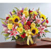 A gorgeous display of colorful blooms arranged in a wicker basket. Includes