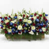 A striking red, white, and blue altar arrangement featuring elegant snapdragons, classic