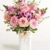 A soft, garden-style bouquet of blush pink roses and pink daisy-like blooms