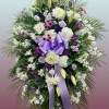 This easel spray is composed of lavender roses, mums, oriental lilies, dianthus