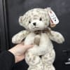 Plush teddy bear with a ribbon bow and hanging tag