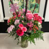 Pink and red mixed flower arrangement in a glass vase