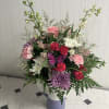 Mixed bouquet in a lavender vase with pink, white, and purple flowers
