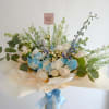 Elegant bouquet in soft blue and white tones, featuring roses, carnations, and