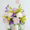 Charming floral arrangement featuring soft lavender and white roses, accented with vibrant