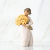 Figurine of a girl holding a bouquet of yellow roses