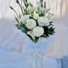 Beautiful arrangement featuring ranunculus, calla lillies, and green accents. 
