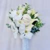Beautiful bridal bouquet featuring white orchids, calla lillies, ranunculus and green accents.