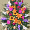 Large standing spray with orange lilies, roses, and purple flowers