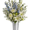 White lilies and blue flowers in a tall metal bucket