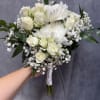White roses and large white chrysanthemums with baby's breath and greenery 