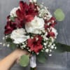 Red alstroemeria and white carnations with soft green and gold pins. Beautifully