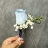 Baby blue rose boutonniere with white filler and green leaves, stem wrapped