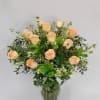 A Dozen peach "Versilia" roses designed in a glass vase with greenery